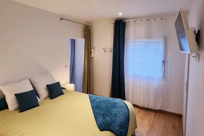 Chambre avec un lit queen size et télévision