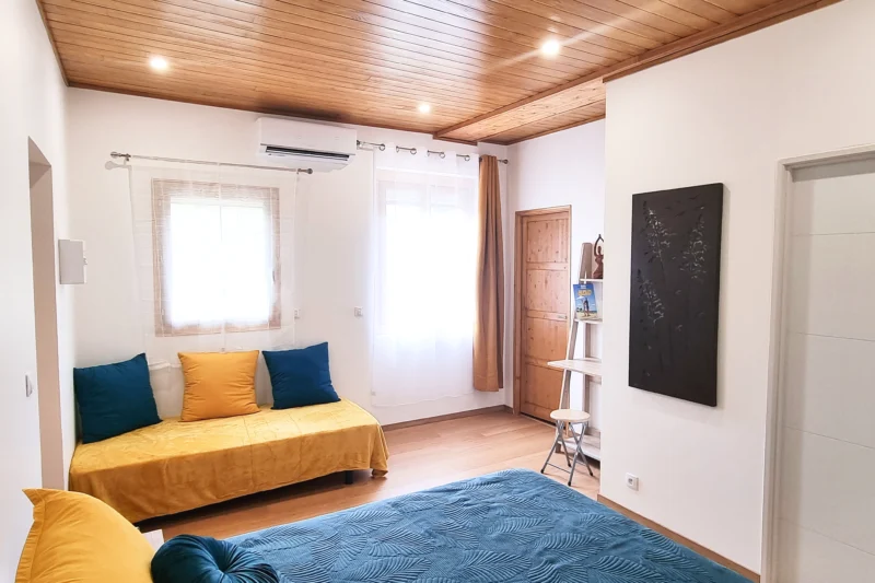 Chambre avec un lit queen size et un lit simple ou canapé. Dresing et salle d'eau moderne.
